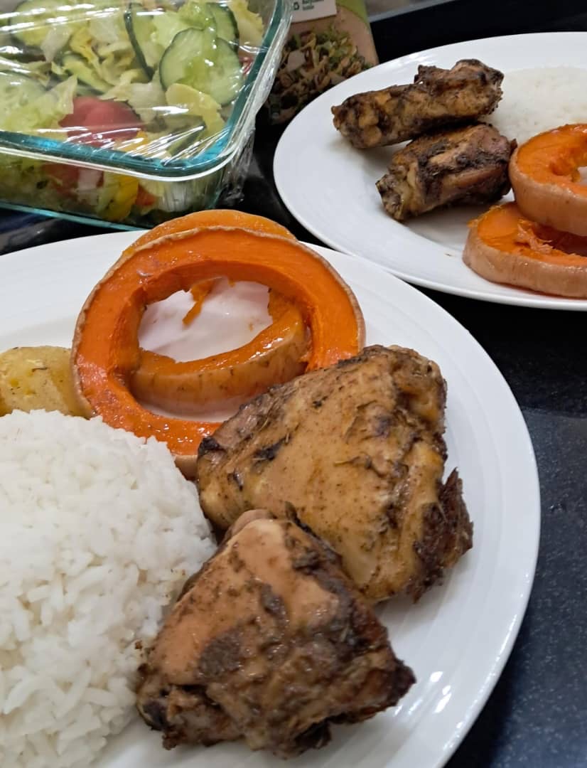 Roast chicken served with rice, pumpkin and salad